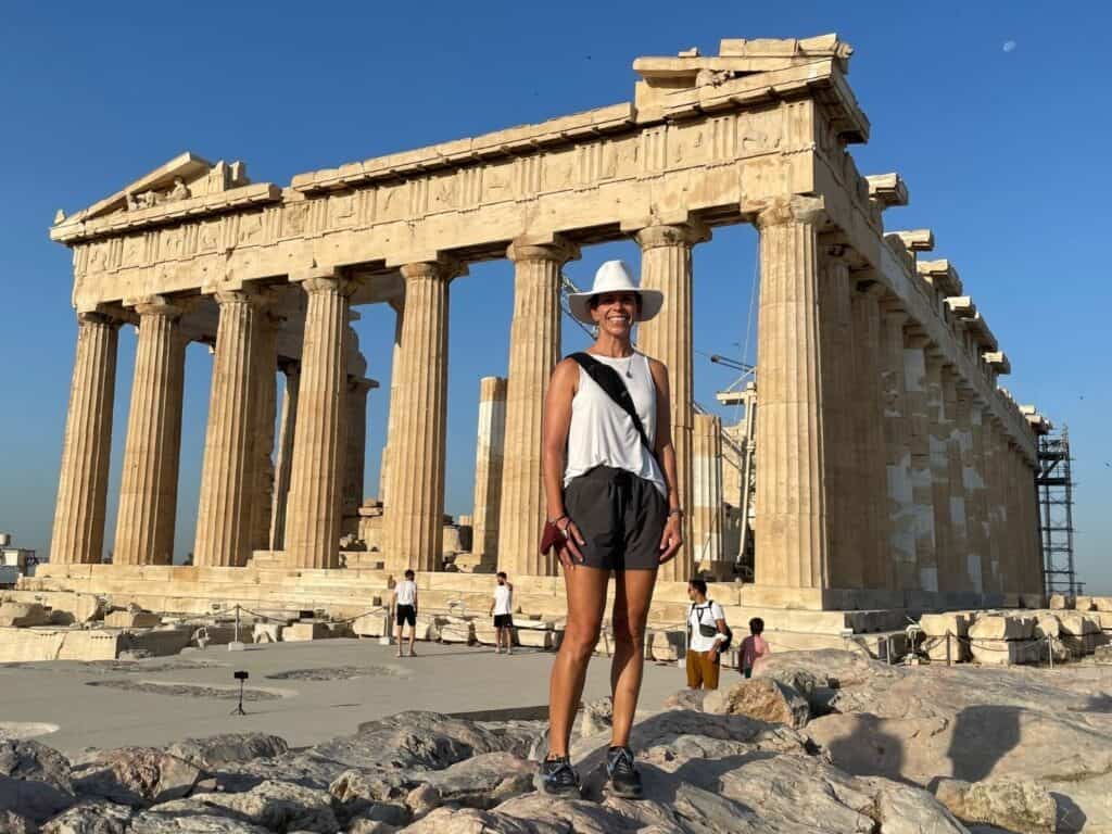 A woman standing in front of ancient ruins