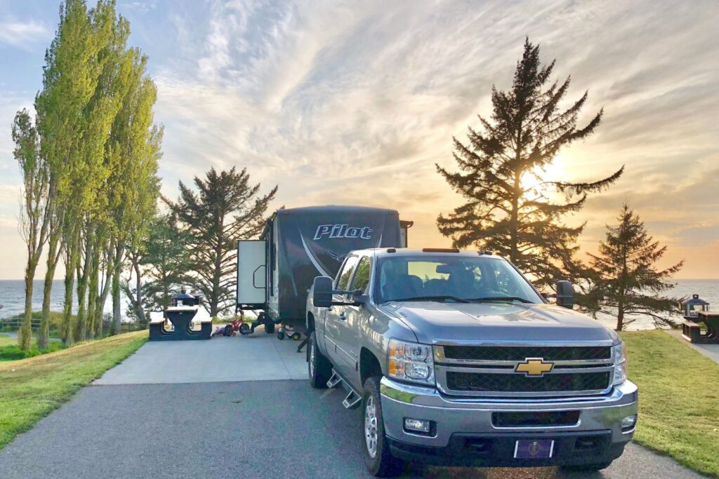 A truck parked in front of an RV with sunset in the background