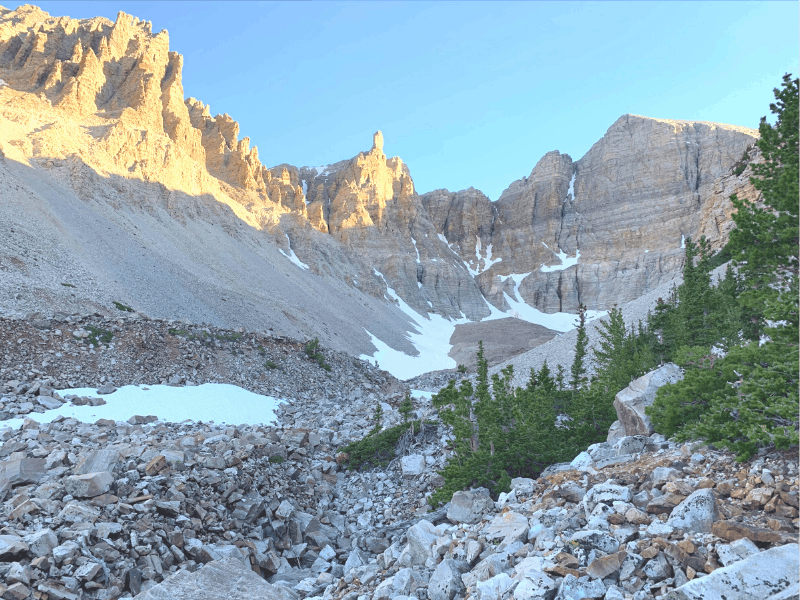 A rocky hiking trail surrounded by mountains