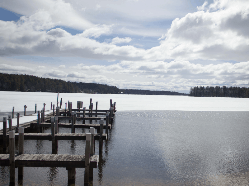 A snow-covered lake and dock in winter