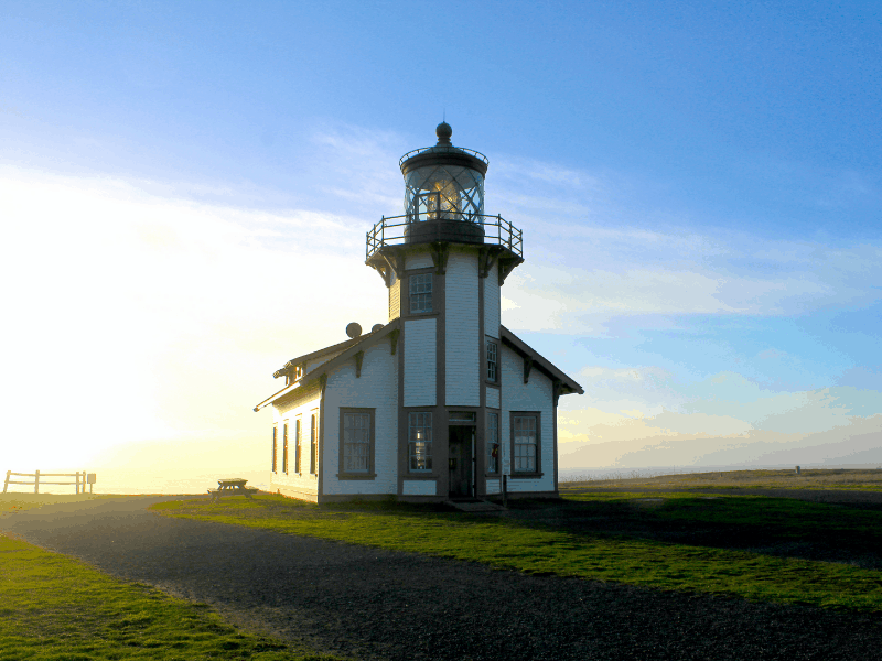 Sun shining on a white lighthouse