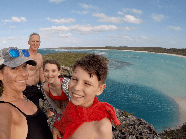 Selfie of the family on mountain with turquoise blue water in the background