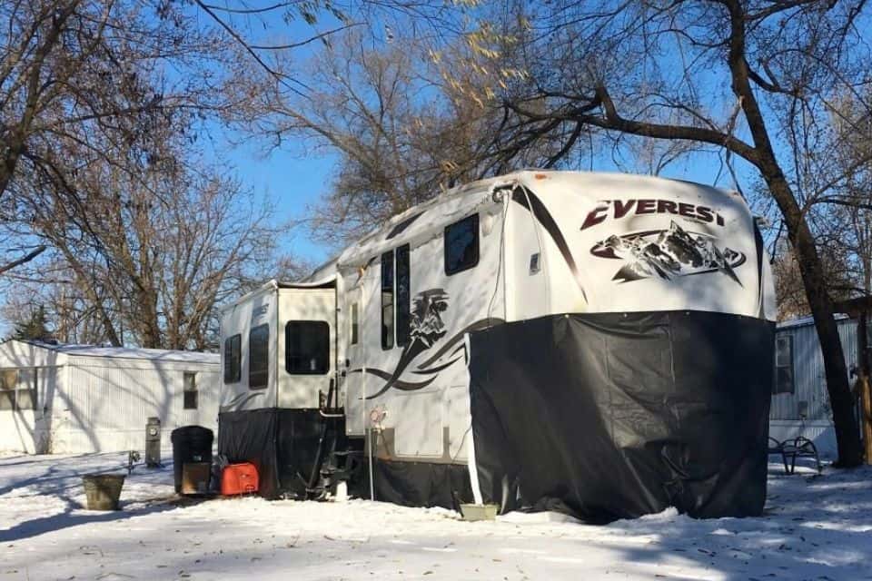 A large RV with black skirting on the front