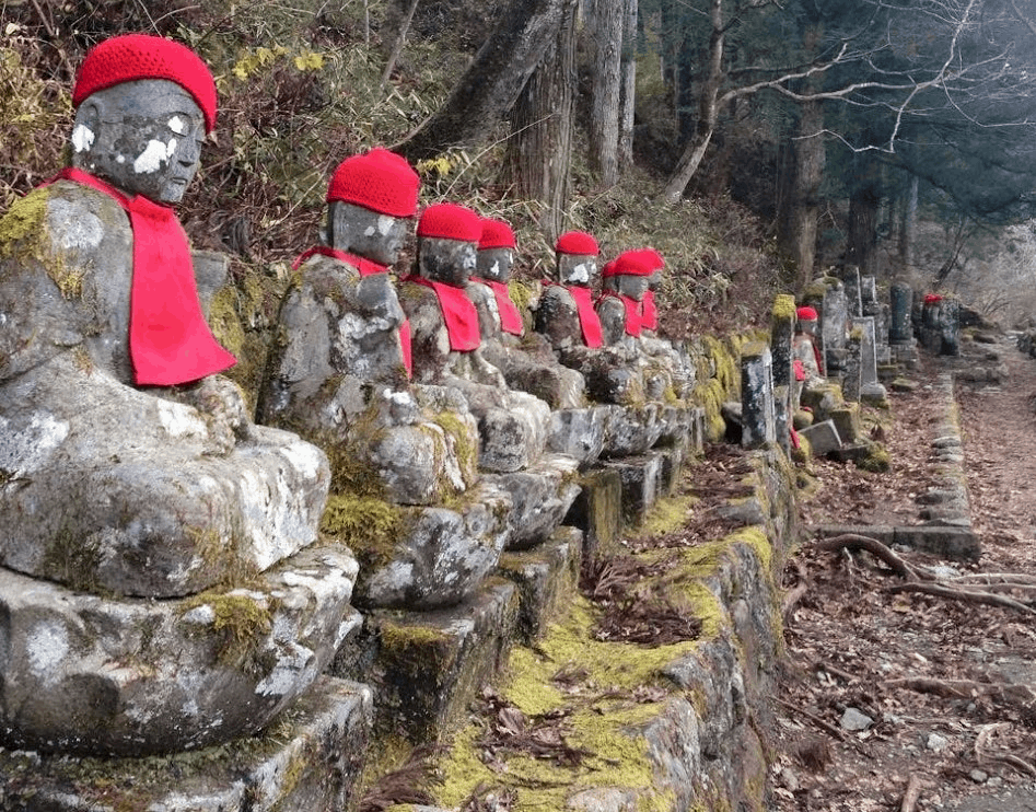 A row of statues, all wearing red hats and scarves