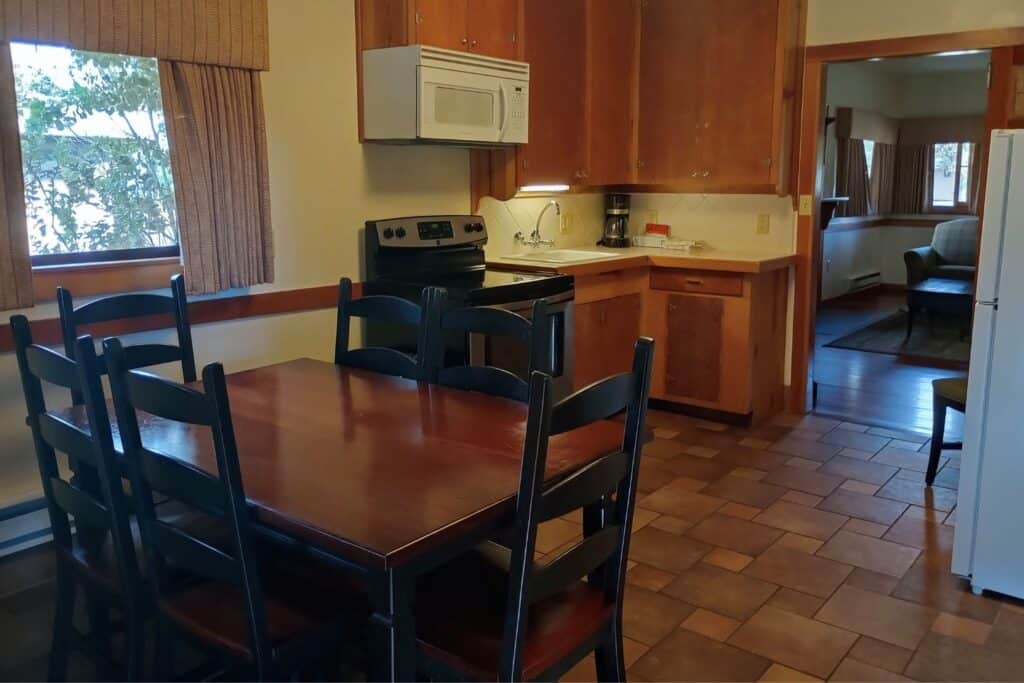 A kitchen with stove and dining table