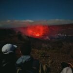 People gathered at a lookout point to watch Kilauea Volcano erupting at night
