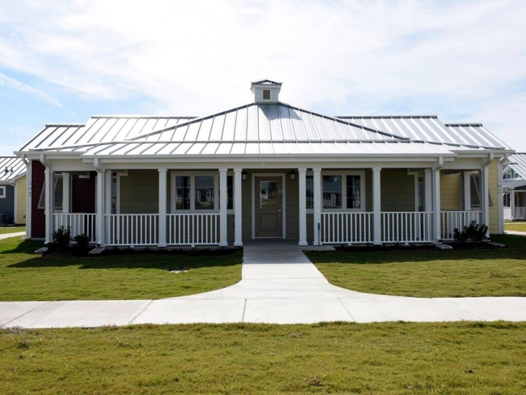 A yellow one-level cottage with a white porch