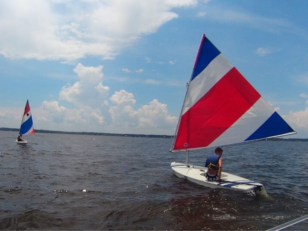 Two small sailboats with red, white, and blue sails