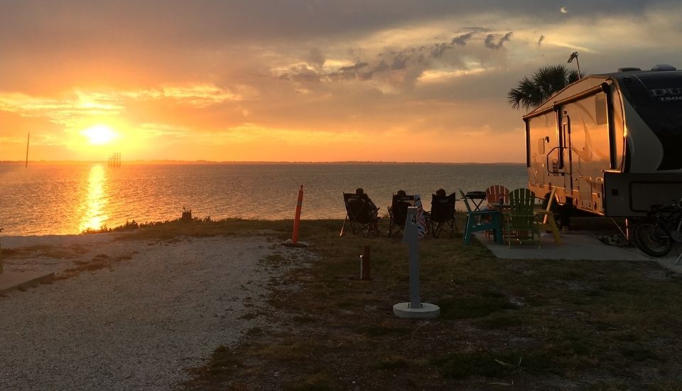 An RV on the beach at sunset