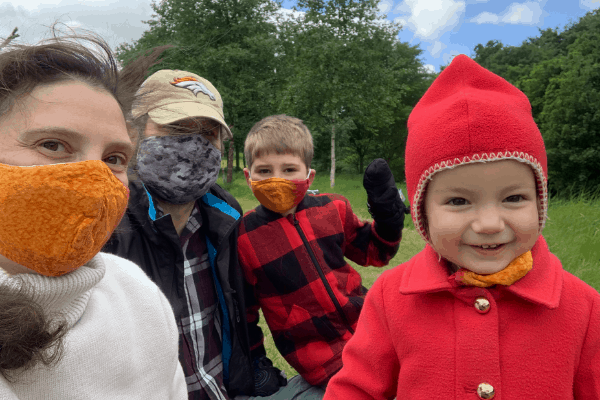 The family at a park wearing face masks