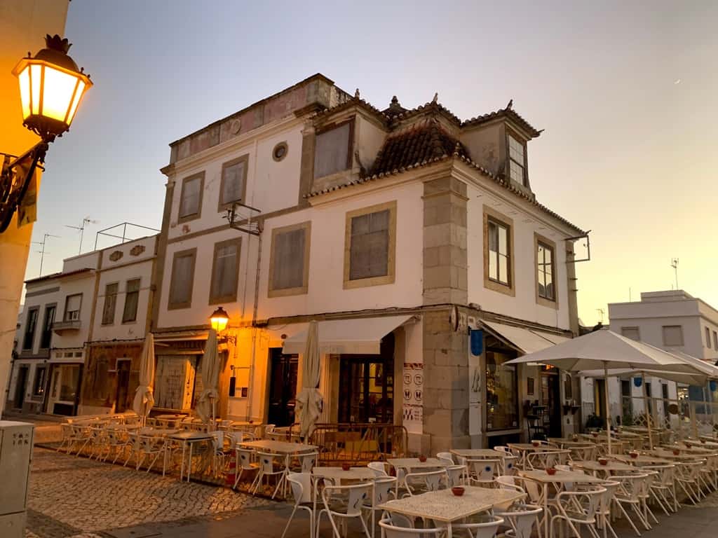 A cafe in Vila Real de Santonio surrounded by white tables and chairs.