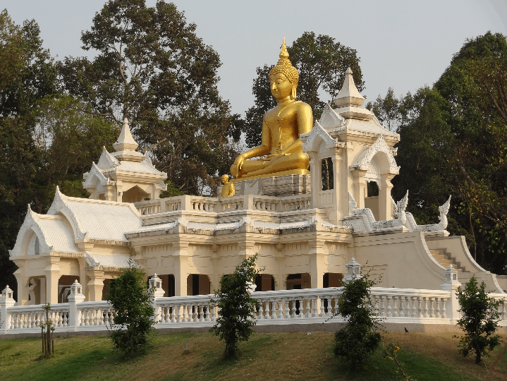 A golden statue sitting atop a white castle