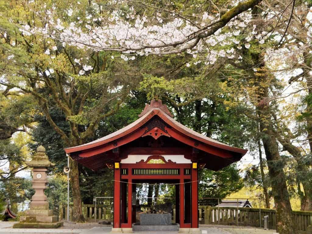 A red shrine in Japan surrounded by trees