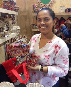 A smiling woman holding baskets in Medellin, Colombia