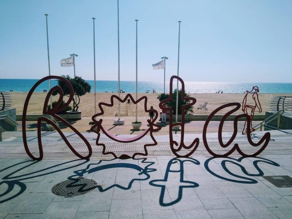 The red Rota sign with the beach in the background
