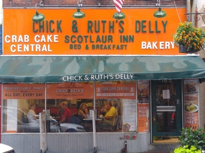The outside of Chick & Ruth's Delly with a bright orange sign and green writing.