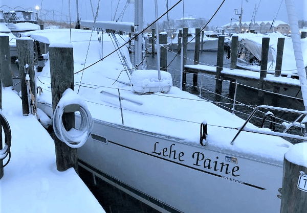 The boat in a marina, covered with snow