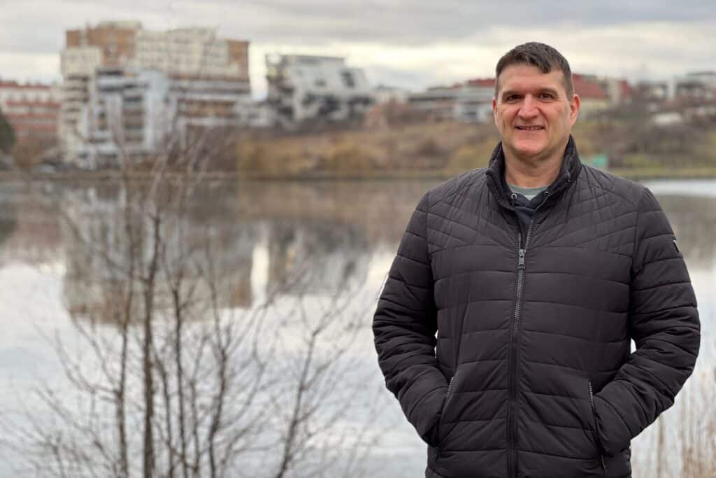 A man standing in front of a lake