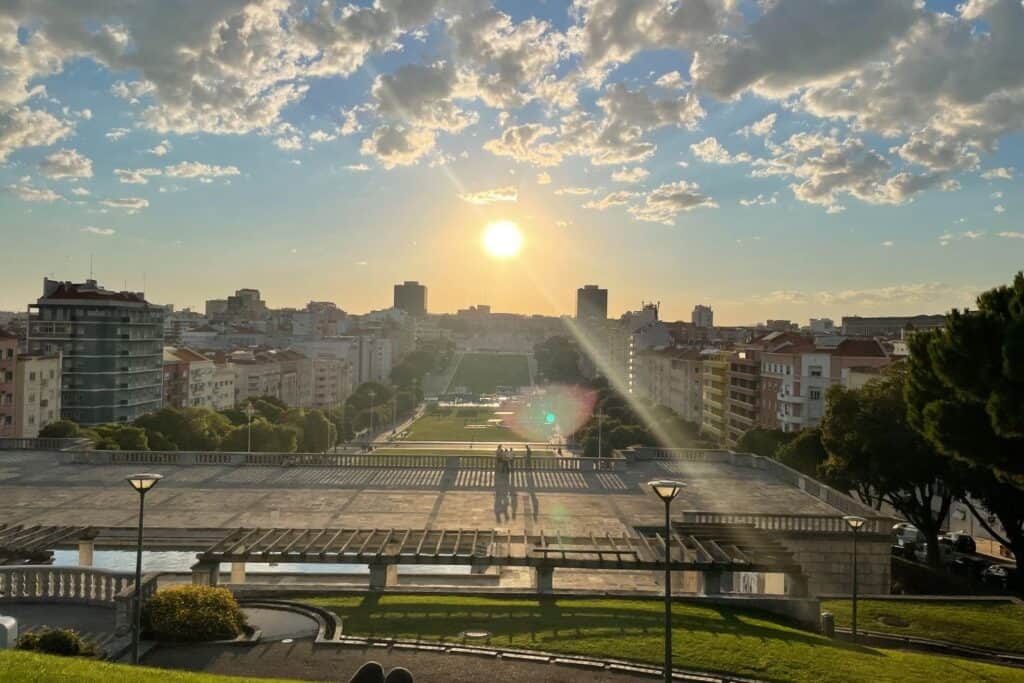 The sun over buildings as seen from a hilltop