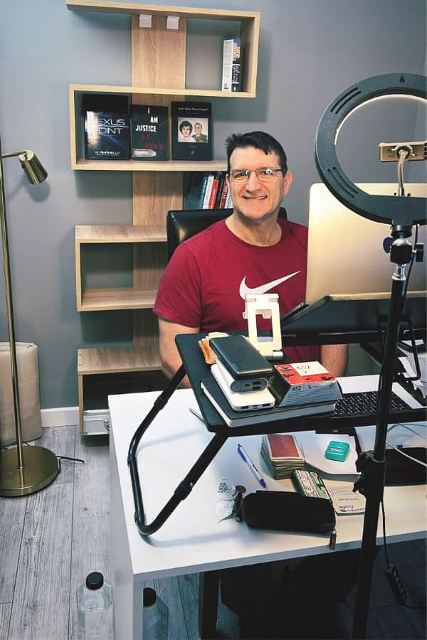 A man sitting at a desk with books behind him