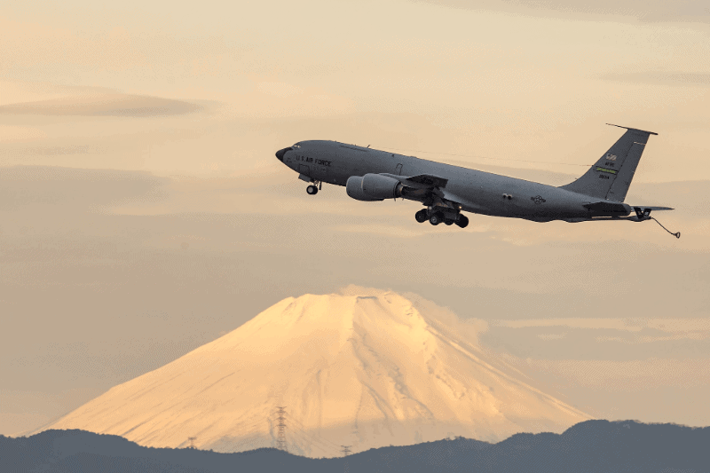 A military airplane taking off with Mt. Fuji in the background